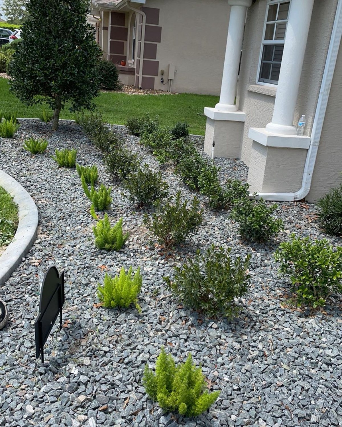Gray rock bed with new plantings beside a home entry